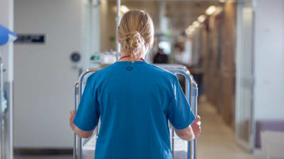 Sjukvårdare går i en sjukhuskorridor. 