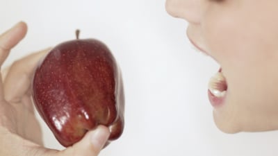 En kvinna äter ett äppel