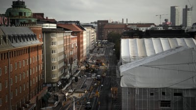 en stadsbild ovanifrån en gata i helsingfors men olika höghus till vänster om gatan 