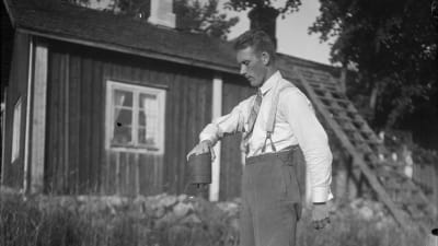 En man lyfter ett tungt lod med sin ena hand. Bilden är tagen 1930 i Bromarf.