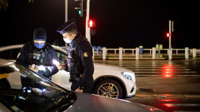 Franska poliser står vid en bil i mörkret, de kollar förarens dokument.