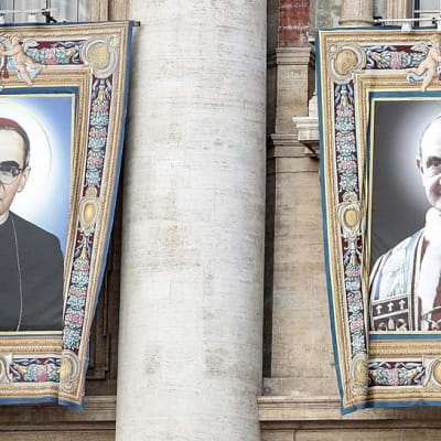 Suuret Romeroa ja Paavali VI:ttä esittävät kankaat roikkuvat parvekkeilta Pietarinkirkon julkisivulla Vatikaanissa.
