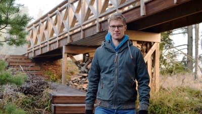 Jonas Lundberg går vid en gångbro i trä.
