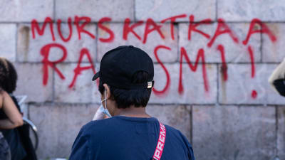 En ung pojke betraktar en graffitimålning på Senatstorget i Helsingfors. 