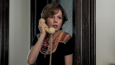 Gail (Michelle Williams) står i dörröppningen med en telefonlur i handen och ser skrämd ut.