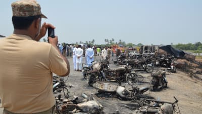 En pakistansk soldat fotograferar olycksplatsen i utkanterna av Bahawalpur, Pakistan 25.6.2017