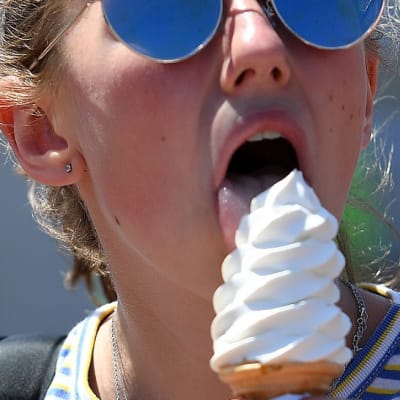 Nuori nainen nuolee jäätelöä. 