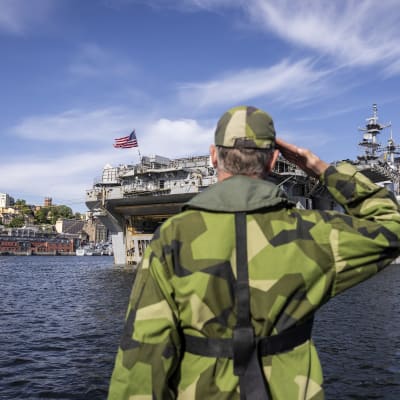 En soldat i givakt framför ett amerikanskt stridsfartyg.