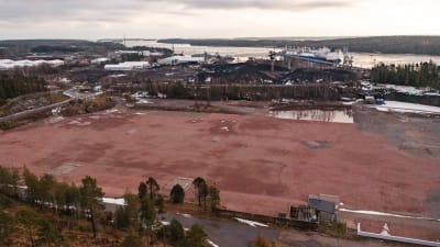 En stor sandplan på ett industriområde i närheten av havet.