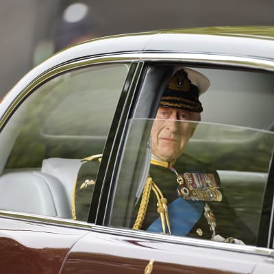 Kuningas Charles katsoo ulos auton ikkunasta.