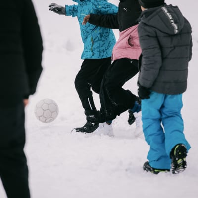 Oppilaat pelaavat jalkapalloa välitunnilla.