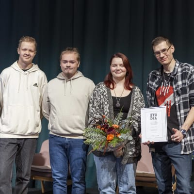 Viisi nuorta seisoo lavalla. Yhdellä heistä on kukkakimppu ja yhdellä kunniakirja.