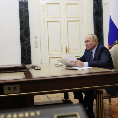 Vladimir Putin sitter vid ett bord