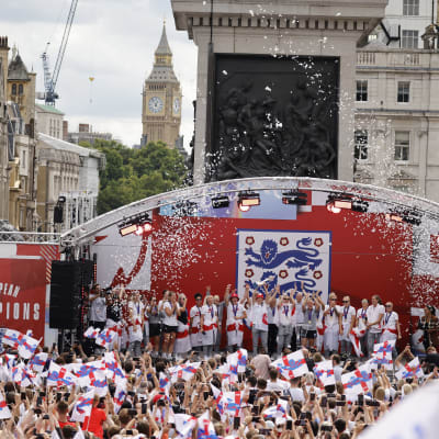 Englenska spelare står på en scen och firar framför fansen.
