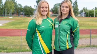 Emilia och Malin Karell står bredvid varandra med SJundeå sportplan i bakgrunden.