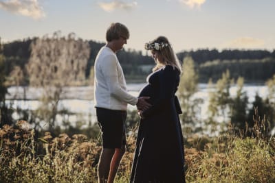 En man och en kvinna står vända mot varandra. Kvinnan väntar barn. De heter Sam och Julia Stenvall.