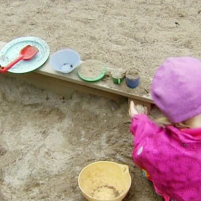 Lapsi päivähoidossa hiekkalaatikolla. 