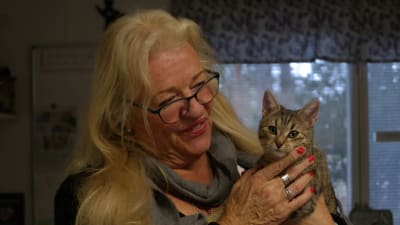 Brill-Marie Juup håller en brun katt i sina händer