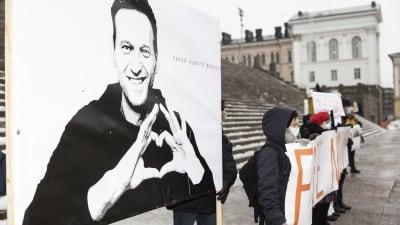Demonstranter utanför Domkyrkan i Helsingfors. I förgrunden en skylt med Alexej Navalnij