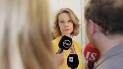 Europa- och ägarstyrningsminister Tytti Tuppurainen får flera mikrofoner framför sig.