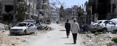 En väg kantad med bombskadade byggnader i Douma i Syrien.