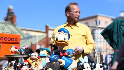 Loppmarknadsförsäljare säljer Disneyfigurer.