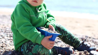 Barn leker i sanden.