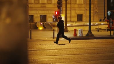 En polis springer på en folktom gata i Paris.