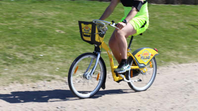 Man cyklar på citycykel i Helsingfors.