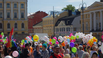 Ballonger i olika färger tillsammns med människor på Senatstorget i Helsingfors under Helsingfors Pride 2016.