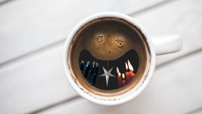 Kaffekopp med kent, ljus, en julstjärna.