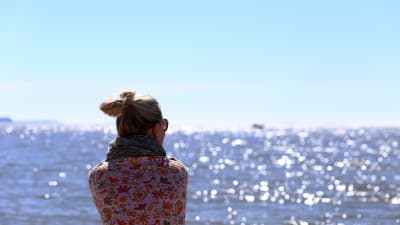 En kvinna tittar ut över havet.