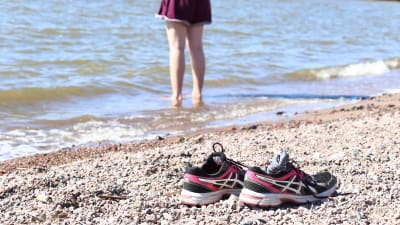 Flicka som står på stranden.