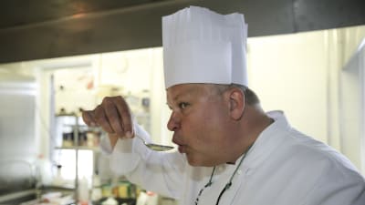 Kocken Mikael Eskman smakar på soppa med en sked.