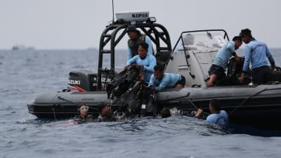 Indonesiska dykare arbetade vid olycksplatsen på tisdagen. 