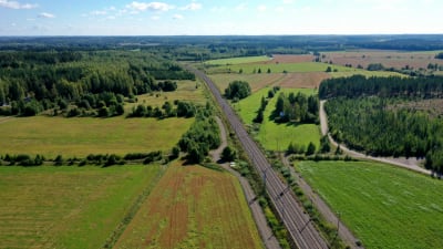 Rautatie halkoo maalaismaisemaa