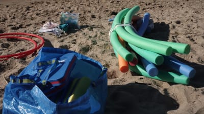 Vattenleksaker på en sandstrand.