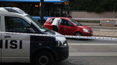 Polisen har spärrat av området där den röda bilen, som varit med om skottlossningen, står.