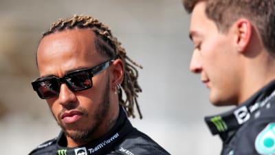 Lewis Hamilton står fokuserad bredvid George Russell.