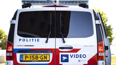 En nederländsk polisbil fotograferad bakifrån medan den är parkerad på en gata.