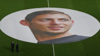 En stor duk med en bild på Emiliano Sala liggandes på en fotbollsplan. 