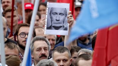 En rysk oppositionssympatisör håller en bild av Vladimir Putin med texten: Vi är trötta på honom. Massdemonstationer hölls i St: Petersburg i slutet av juli, där deltagarna krävde att oppositionskandidater skulle inkluderas på vallistorna. 