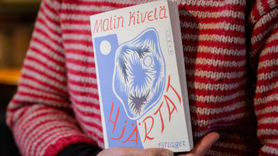 Kirjailija Malin Kivelä selaa kirjaansa " Hjärtat "