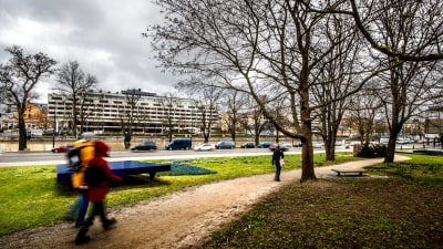 Fotgängare promenerar längs ett gångstråk invid Aura å