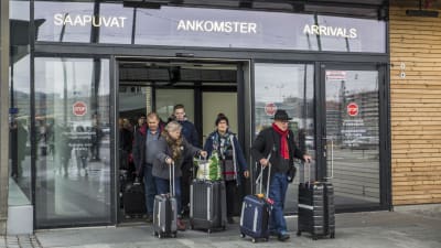 Människor med reseväskor lämnar Västra terminalen i Helsingfors.