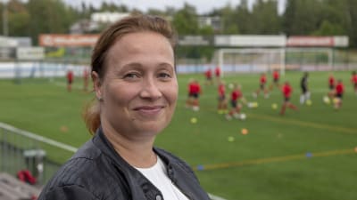 Jalkapalloa harrastavan pojan äiti Helena Sarso puolilähikuvassa, kuvattu Espoonlahden urheilupuistossa.