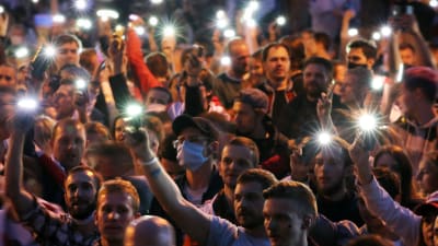En stor grupp människor håller upp sina mobiltelefoner