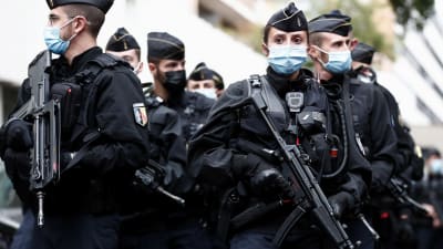 Flera poliser med automatvapen stor i en klunga