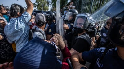 Protester utanför parlamentsbyggnaden i Tunis. Polisen sammardrabbar med demonstranter.