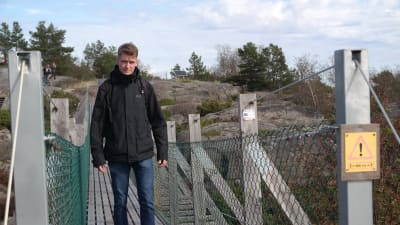 Mikael Nordström går på en hängbro på Örö